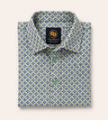 Neatly folded kids button-down shirt highlighting the intricate green and navy circular geometric pattern and matching light green buttons.