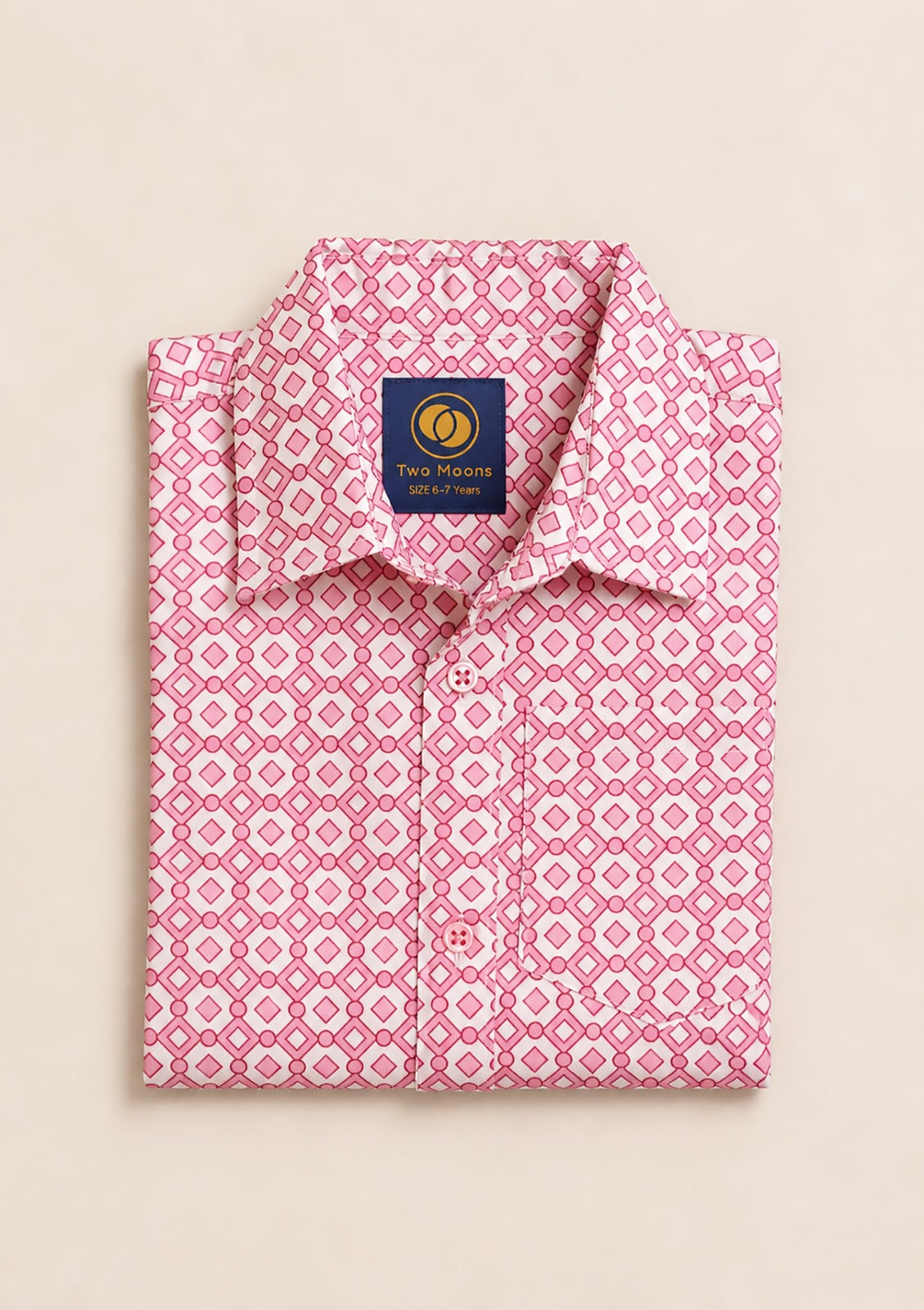 Neatly folded pink and white kids button-down shirt highlighting the geometric diamond pattern and matching pink buttons.