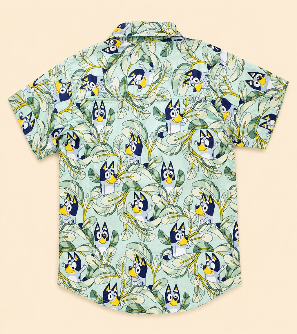 Two Moons Canada kids short-sleeve button-down shirt back side featuring a cartoon blue dog and tropical green leaves on a mint background.