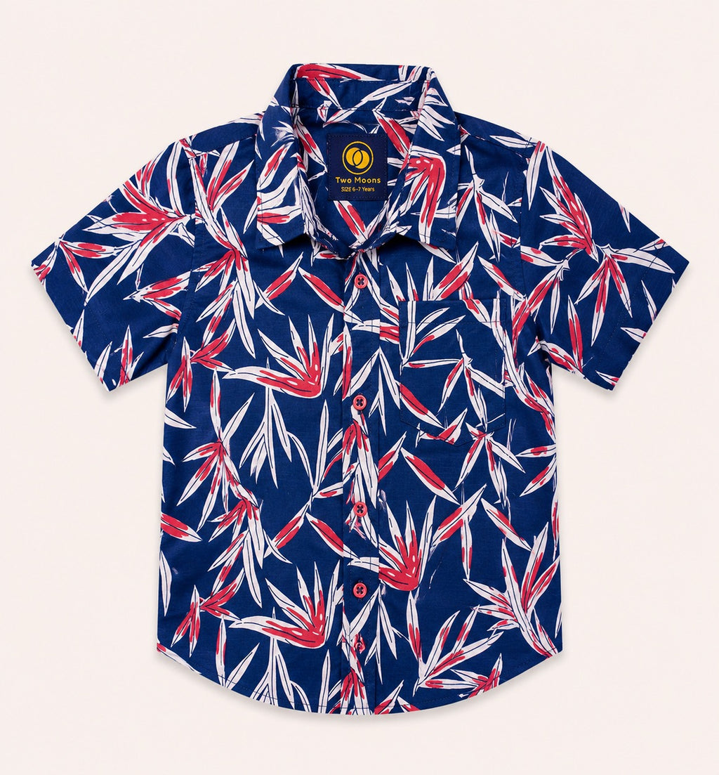 Front view of a navy blue kids short-sleeve button-down shirt featuring a vibrant red and white tropical leaf print with matching red buttons.
