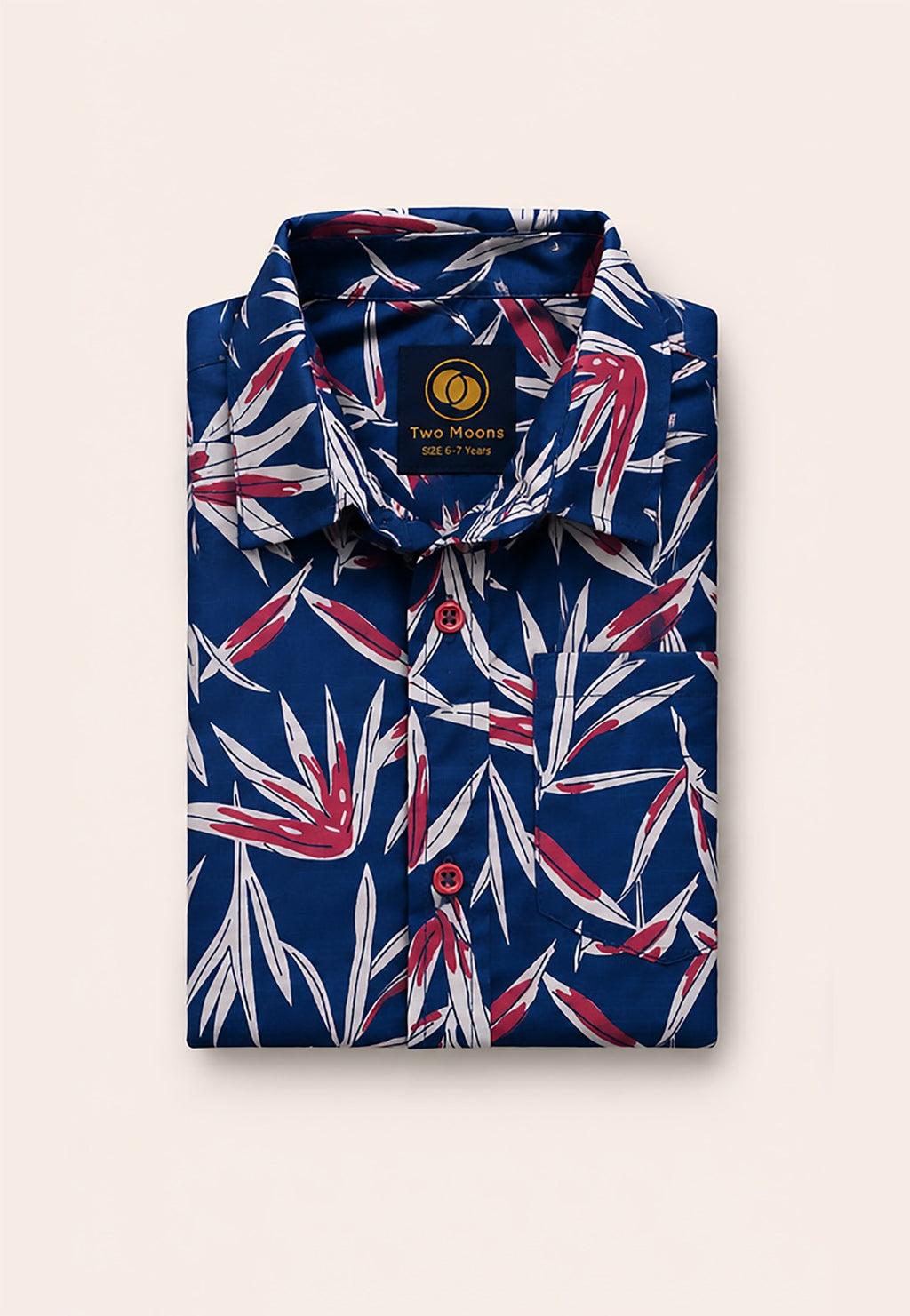 Neatly folded navy blue kids button-down shirt highlighting the striking red and white tropical leaves and vivid red buttons.
