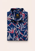 Neatly folded navy blue kids button-down shirt highlighting the striking red and white tropical leaves and vivid red buttons.