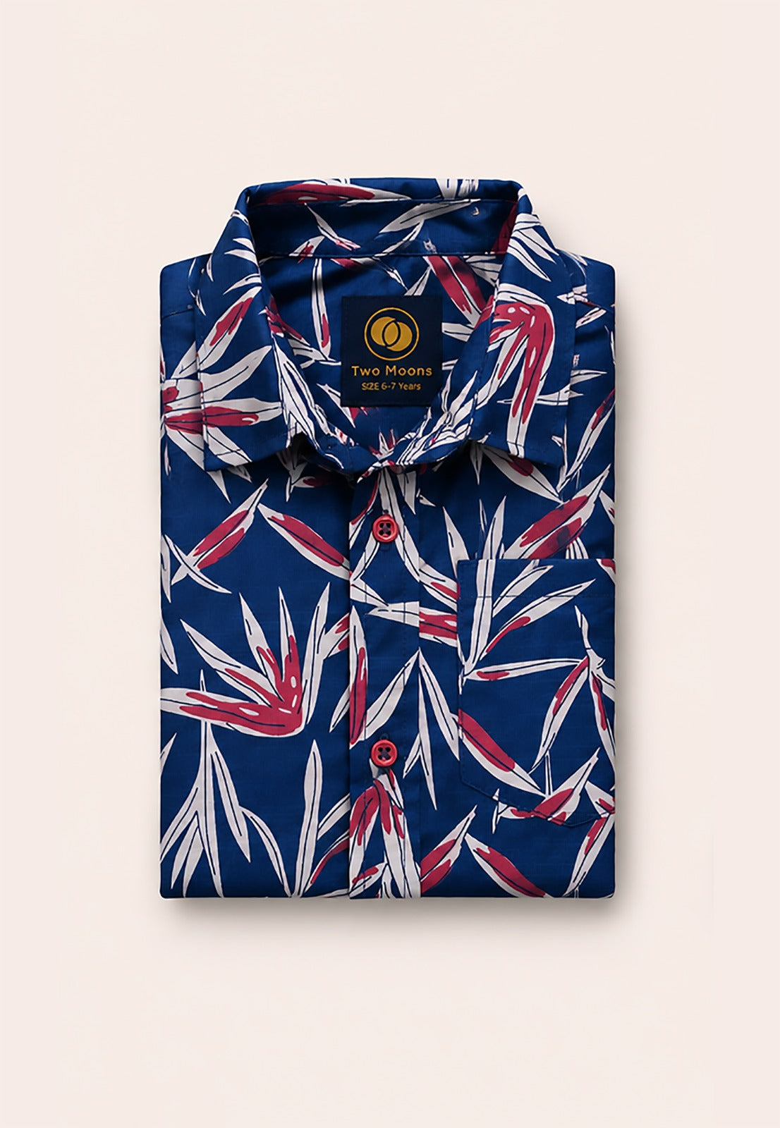 Neatly folded navy blue kids button-down shirt highlighting the striking red and white tropical leaves and vivid red buttons.