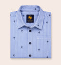 Neatly folded light blue and white striped kids button-down shirt highlighting the small palm tree motif and contrasting dark navy buttons.