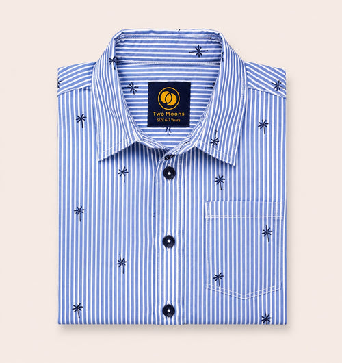 Neatly folded light blue and white striped kids button-down shirt highlighting the small palm tree motif and contrasting dark navy buttons.