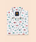 Neatly folded white kids button-down shirt highlighting the colorful car, house, and tree motif along with classic clear buttons.