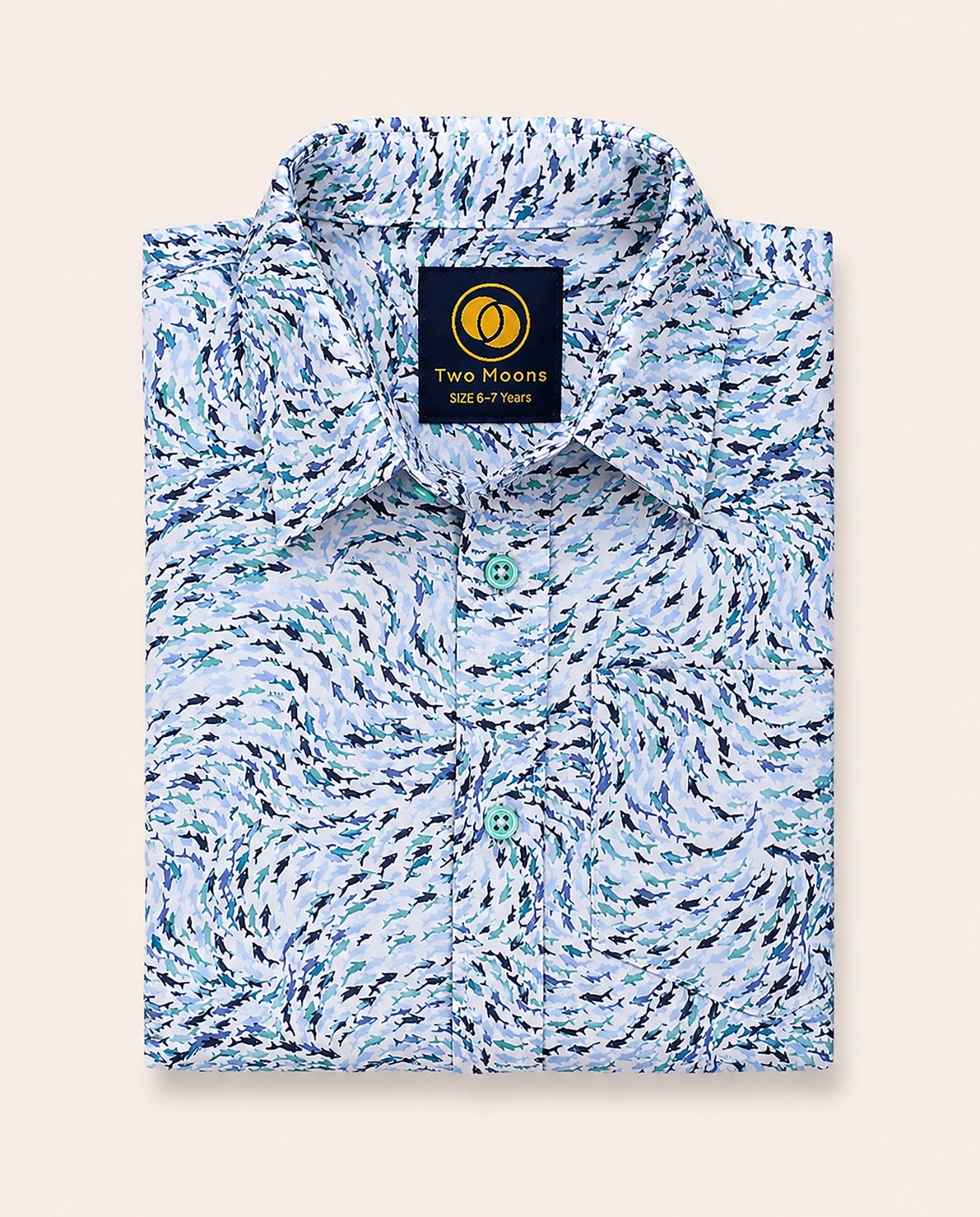 Neatly folded kids button-down shirt highlighting the swirling blue abstract wave print and contrasting light teal buttons.