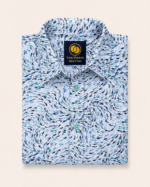 Neatly folded kids button-down shirt highlighting the swirling blue abstract wave print and contrasting light teal buttons.