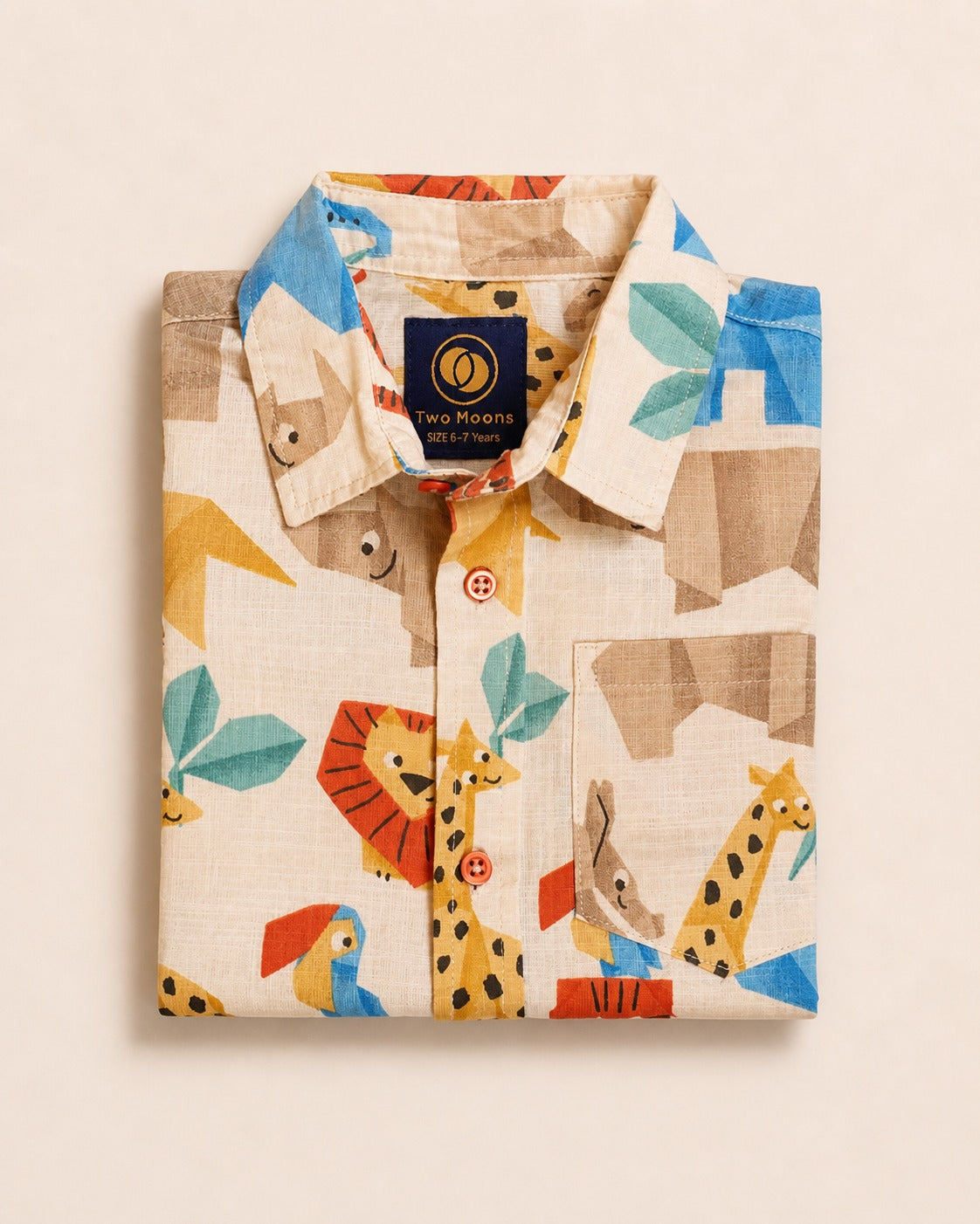 Neatly folded cream kids button-down shirt showcasing the colorful geometric safari animal origami pattern and contrasting orange buttons.